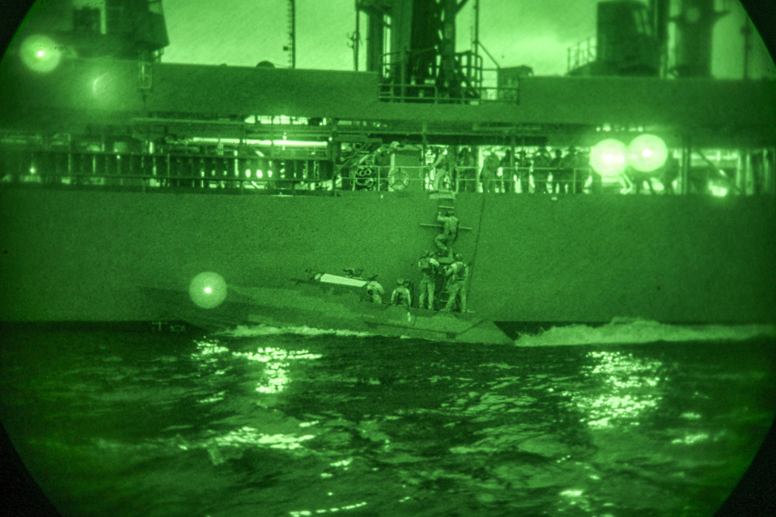 Operators board fleet replenishment oiler USNS Pecos (T-AO 197) during nighttime maritime interdiction operations training off the coast of southern California.